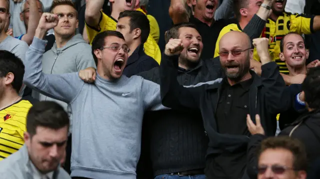 Watford fans celebrate their goalkeeper saving a penalty