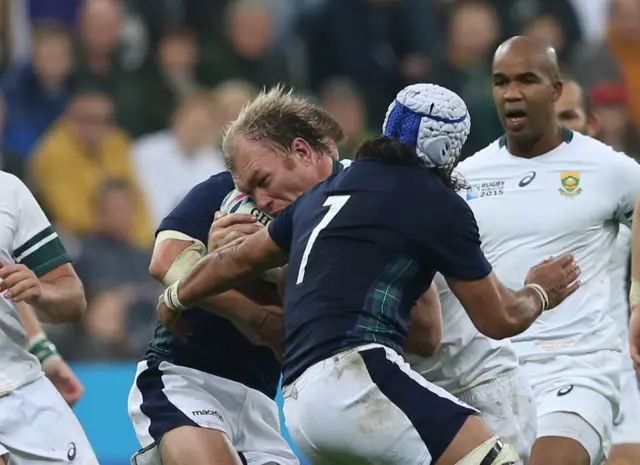 South Africa's Schalk Burger is tackled by Scotland's Blair Cowan