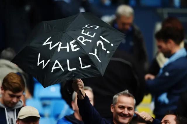 A Manchester City fan holds an umbrella marked "Where's Wally"