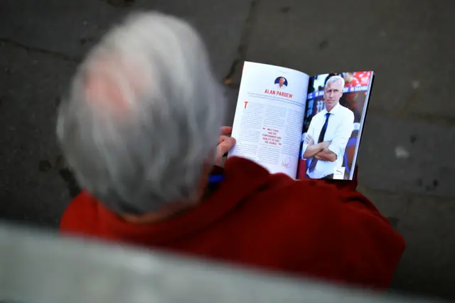 A fan reads a matchday programme