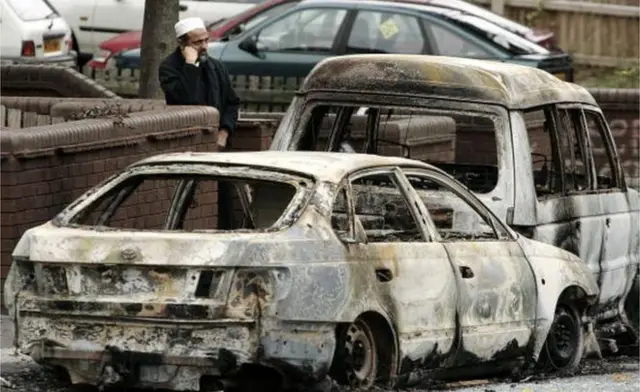 A local man is seen near burnt out vehicles in Lozells area on October 23, 2005 in Birmingham