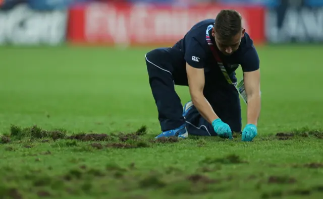 A member of ground staff tends to the pitch