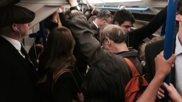 Passengers on a London Underground rain