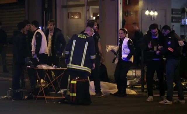 Rescue workers and medics work by victims in a Paris restaurant