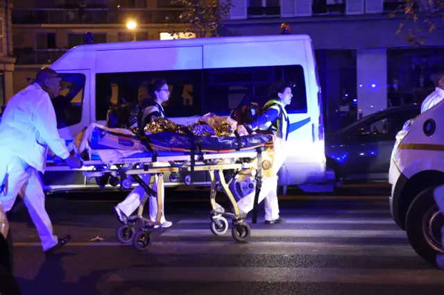 Rescuers evacuate an injured person on Boulevard des Filles du Calvaire, close to the Bataclan concert hall in central Paris,