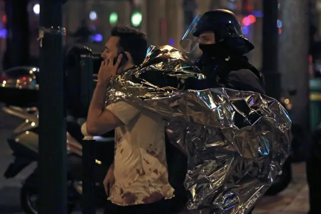 A man with blood on his shirt outside the Bataclan music hall