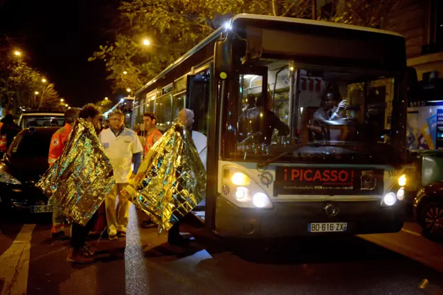 Survivors board a bus after gunfire in the Bataclan concert hall