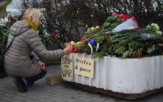 People lay flowers in front of the embassy of France in Moscow