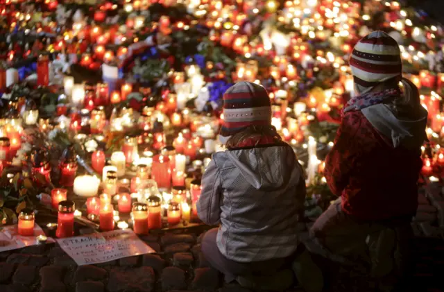 Two children in front of flowers and candles in Prague, Czech Republic