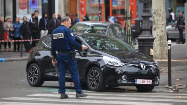 A police officer stands by a Renault Clio with Belgian license plates in Paris on Tuesday 17 November 2015