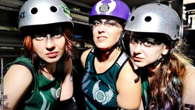 Three roller derby skaters look