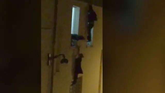 Woman clinging to a window of the Bataclan theatre during the Paris attacks