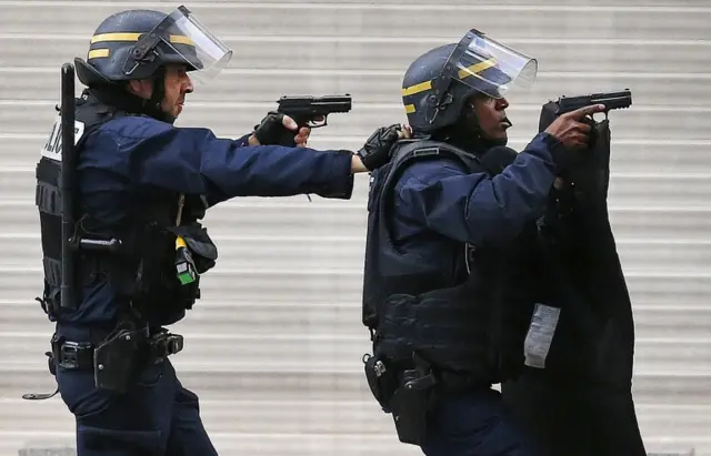 Armed police holding up guns