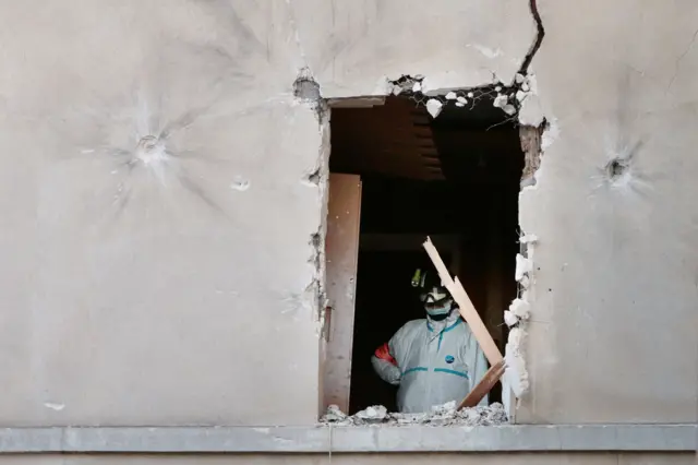 A member of a forensic team with French police searches for evidence in the flat raided by French Police special forces