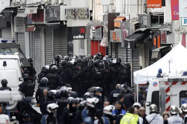 Police gather near the site were a raid happened in the suburb of Saint Denis, near Paris