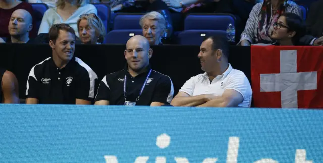 Members of the Australian rugby union team including Stephen Moore, centre, and Australia"s head coach Michael Cheika watch play