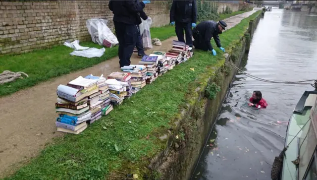 Soggy books are fished out of the canal