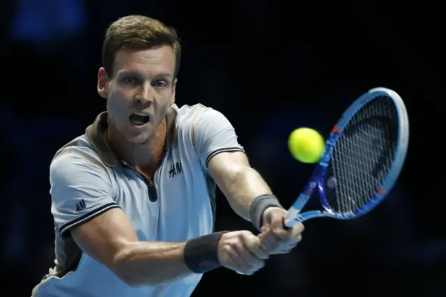 Tomas Berdych plays a shot against Novak Djokovic