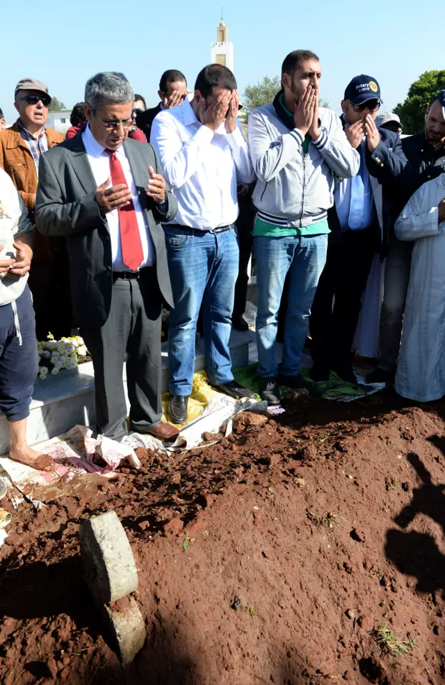 Relatives pray over the grave of Amine Ibnolmobarak, a Moroccan architect who was killed during the terrorist attacks in Paris last Friday, during his funeral at a cemetary in the capital Rabat