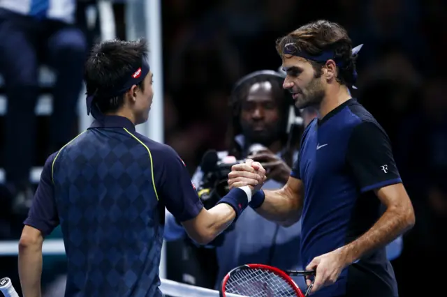 Roger Federer and Kei Nishikori shake hands over the net