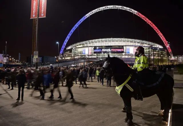 Mounted police personnel keep watch as football fans leave Wembley Stadium following the friendly football match between England and France at Wembley Stadium in west London on November 17, 2015.