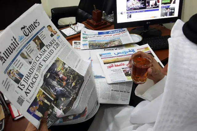 A Kuwaiti man reads a local newspaper, which bears a headline of the deadly Paris attack that left more than 120 people dead, at his office in Kuwait City on November 15, 2015.