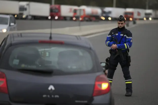 An armed French gendarme stands along the road as they check vehicles and verify the identity of travellers on the A1 motorway between Paris-Lille-Brussels