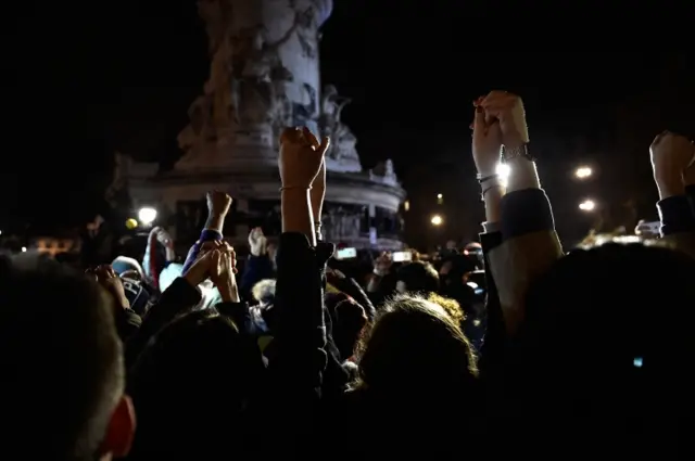 People hold hands in Place de la Republique