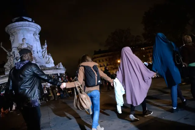 People hold hands in Place de la Republique