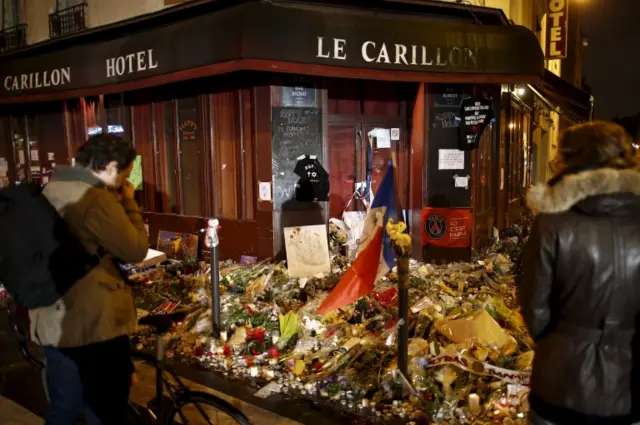 People mourn outside Le Petit Cambodge and Le Carillon restaurants