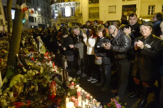 People applaud while at a memorial for the victims of the Paris attacks, near La Belle Equipe cafe on Rue de Charonne in Paris