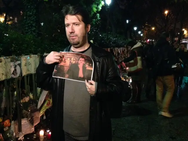 Christophe Naudin holding a photograph of his friend