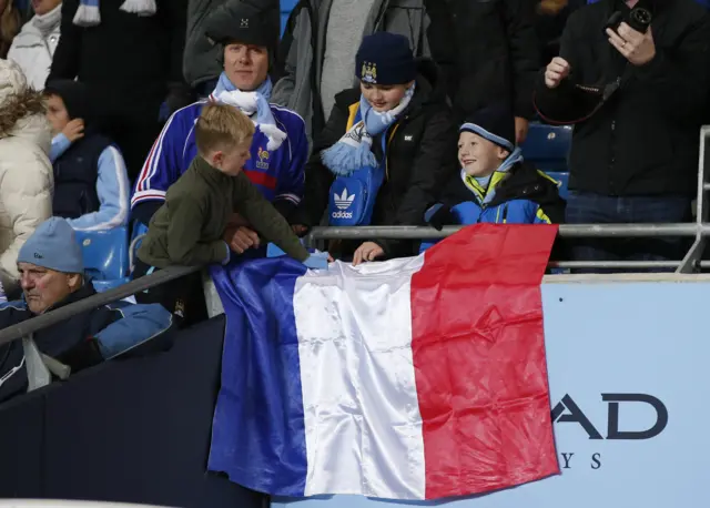 Manchester City fans putting up a French flag