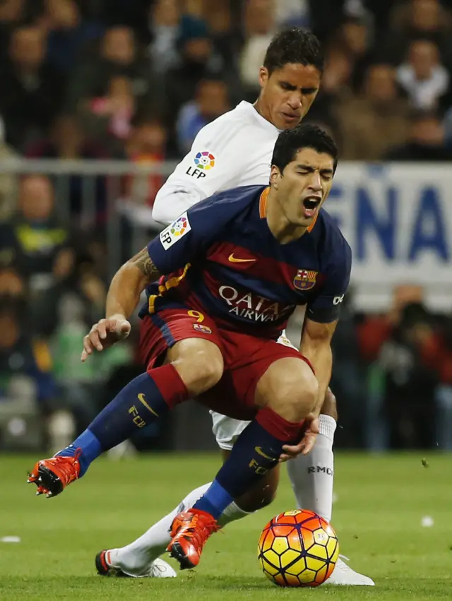 Raphael Varane tackles Luis Suarez