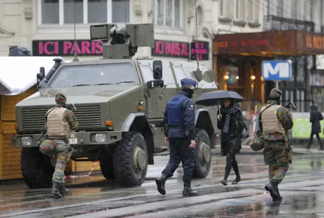 Belgian soldiers and a police officer patrol in central Brussels