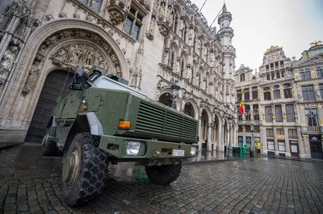 A military truck is stationed at the Grand Place in front of the City Hall in Brussels