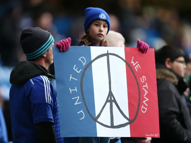 A Chelsea fan holds a banner in support of the recent Paris attacks