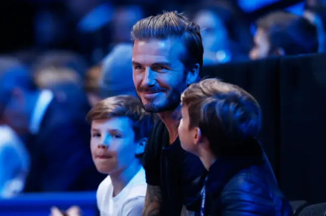 David Beckham watching the tennis with his sons