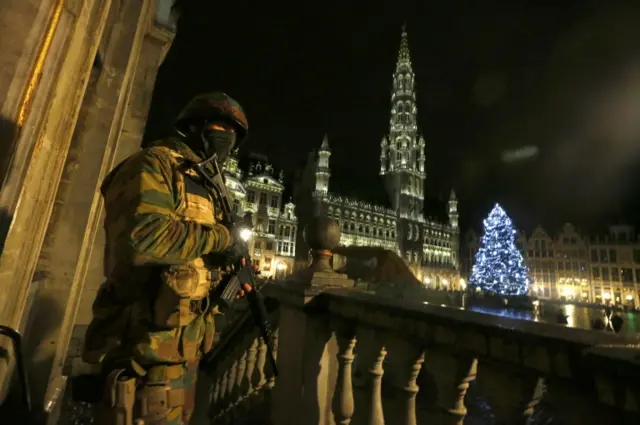 A Belgian soldier stands guard over the Grand Place of Brussels as police searched the area