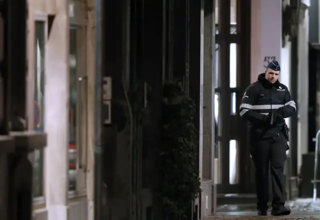 Belgian police officers search the area during a continued high level of security