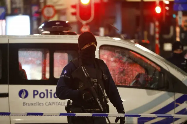 A Belgian policeman stands guard over the Grand Place in Brussels as police searched the area