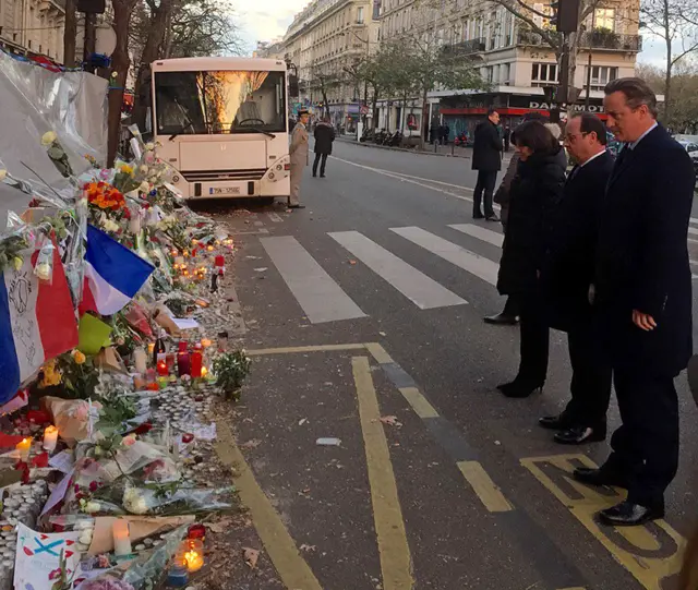 This Monday Nov. 23, 2015 photo taken with permission from the Twitter feed of Britain"s Prime Minister David Cameron showing him with French President Francois Hollande paying their respects outside the Bataclan in Paris