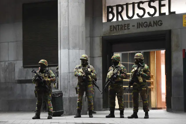 Soldiers stand guard outside a train station