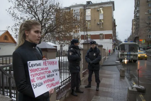 A woman holds a poster as she pickets the Turkish Embassy in Moscow, Russia