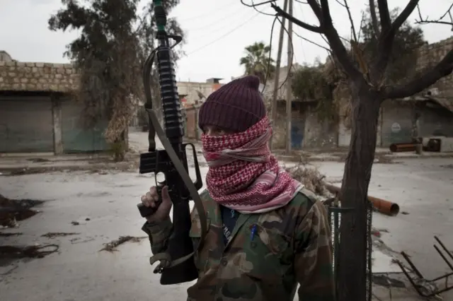 A masked Syrian Turkmen rebel in Aleppo