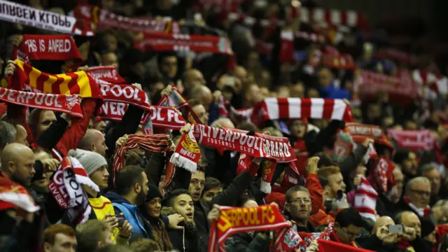 Liverpool fans hold up scarves before kick off