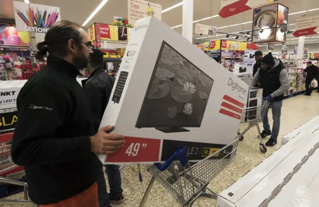 Shoppers with a TV on a trolley