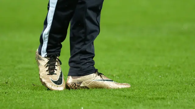 Jamie Vardy wears a pair of gold coloured football boots