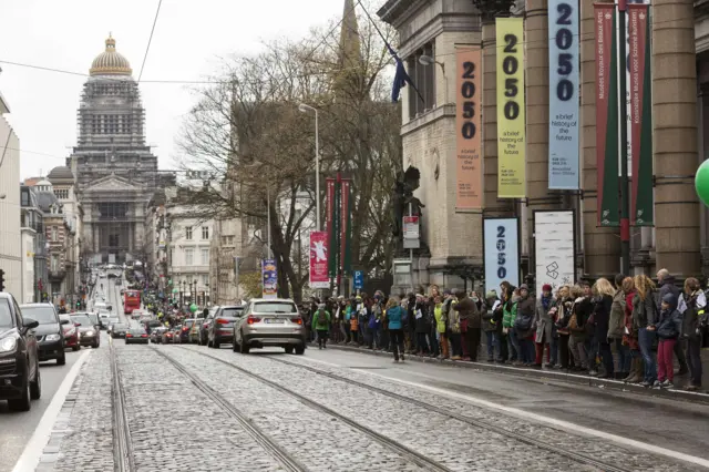 Demonstrators line a boulevard with linked hands