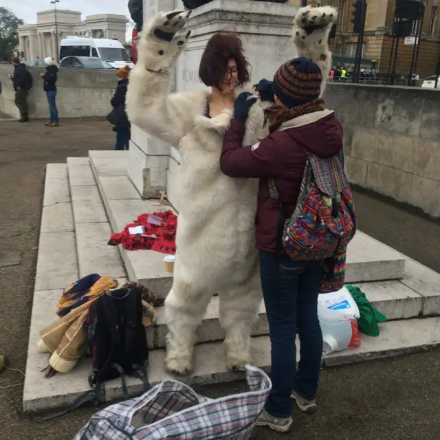 protester getting dressed as a polar bear